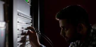 A data storage employee works on a server.