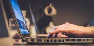 An employee types on a laptop.