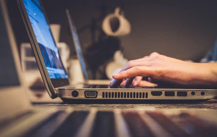 An employee types on a laptop.