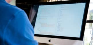 A software engineer reviews code on a monitor.