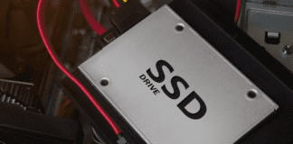 SSD drive laying on computer case with cables and mounts.