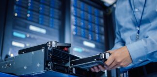 In the Modern Data Center: IT Engineer Installs New HDD Hard Drive and Other Hardware into Server Rack Equipment. IT Specialist Doing Maintenance, Running Diagnostics and Updating Hardware.